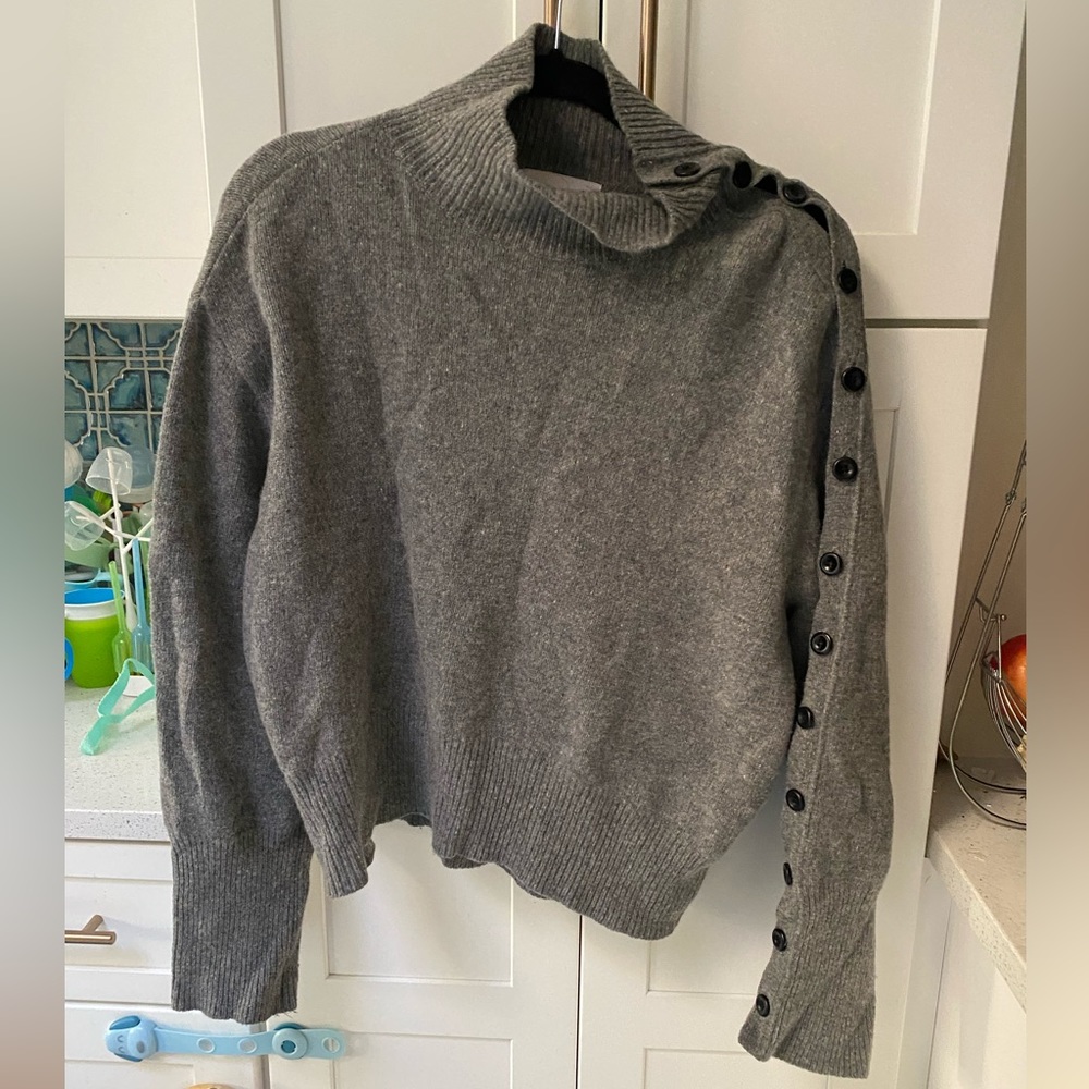 Lambs wool sweater with black button along sleeve